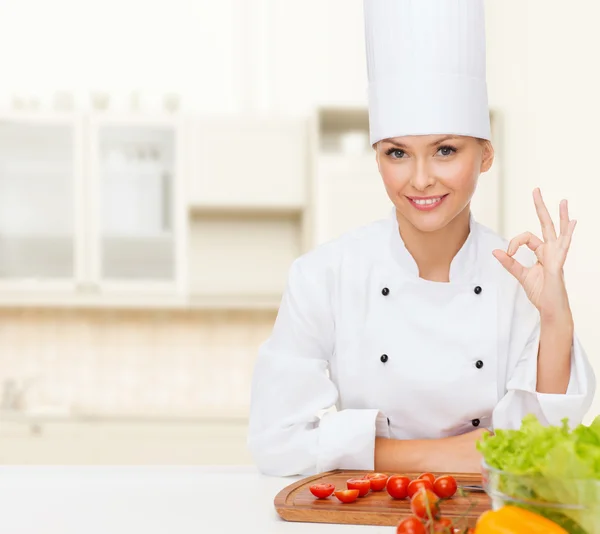 Chef femenino con verduras mostrando signo ok —  Fotos de Stock