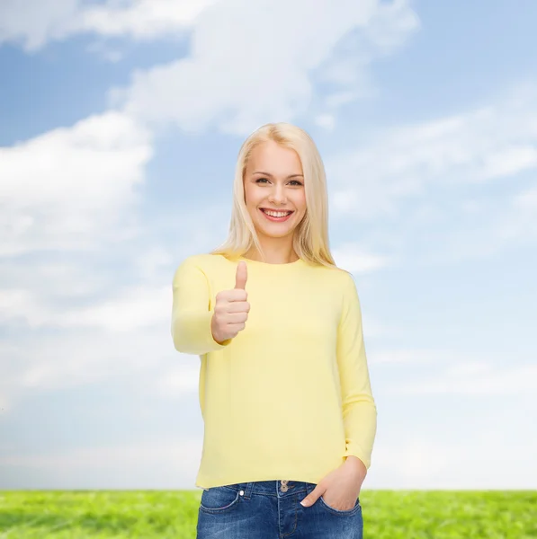 Souriante fille en vêtements décontractés montrant pouces vers le haut — Photo