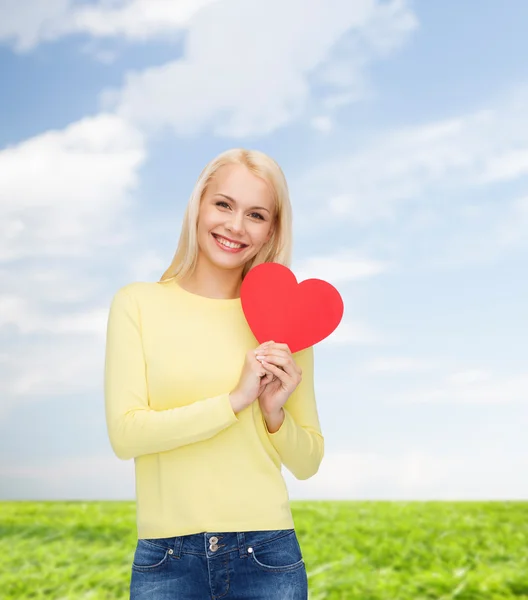 Lachende vrouw met rood hart — Stockfoto