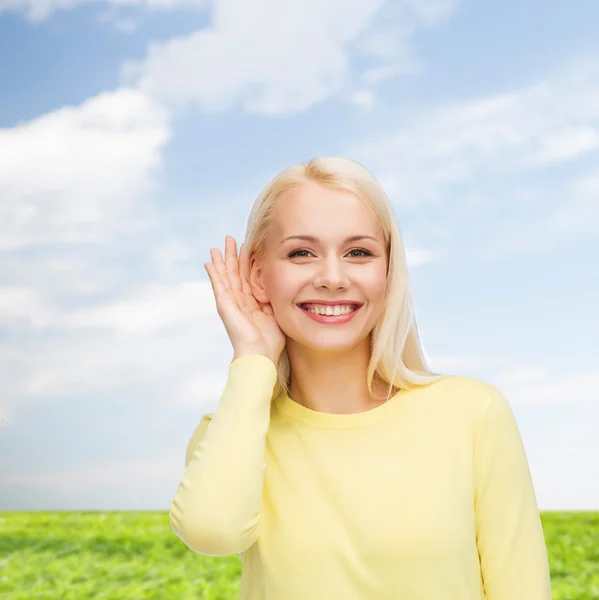 Sorrindo jovem mulher ouvindo fofocas — Fotografia de Stock