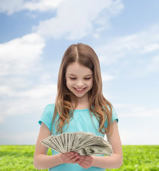 Χαμογελώντας κοριτσάκι κοιτάζοντας Δολάριο μετρητά χρήματα — Φωτογραφία Αρχείου