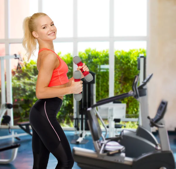 Sonriente hermosa mujer deportiva con mancuernas —  Fotos de Stock