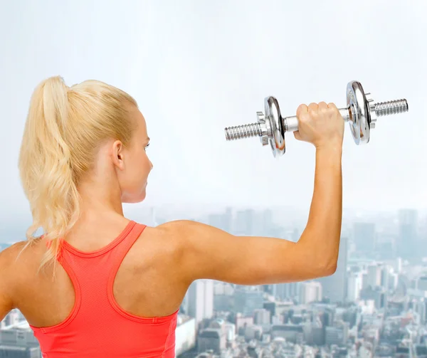 Sportieve vrouw met zware stalen dumbbell van terug — Stockfoto