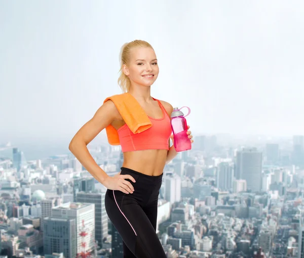Mujer deportiva sonriente con botella de agua y toalla — Foto de Stock