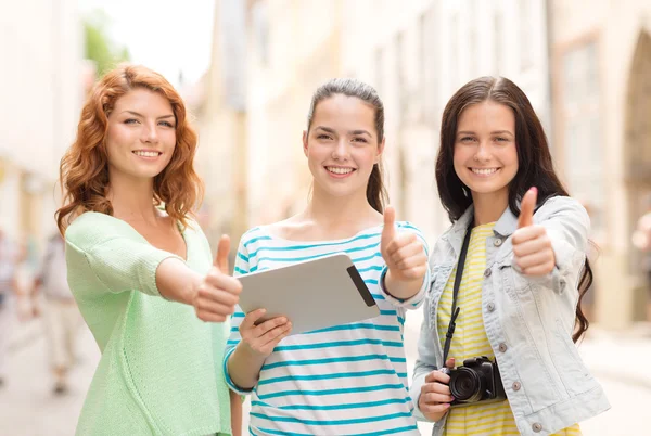 Lachende tienermeisjes met tablet pc en camera — Stockfoto