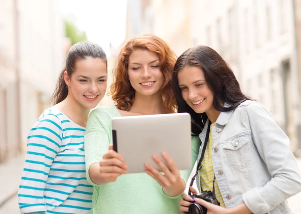 Lachende tienermeisjes met tablet pc en camera — Stockfoto