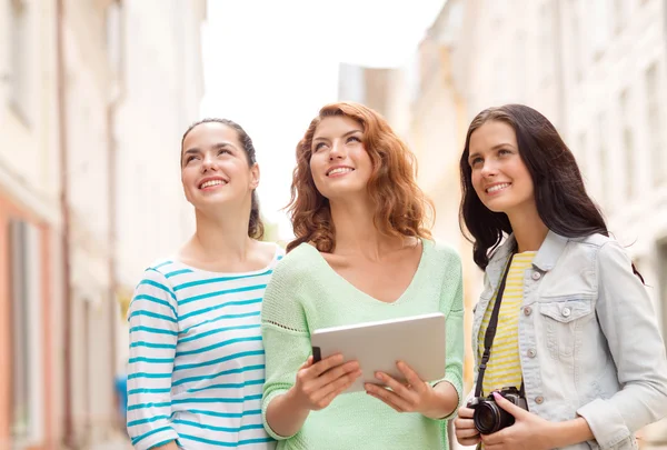 Souriant adolescentes avec tablette pc et caméra — Photo