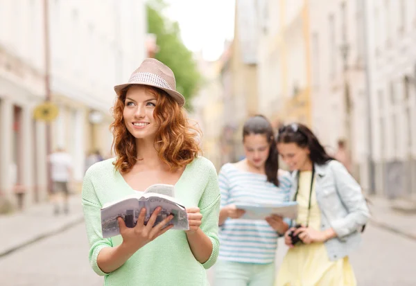 Lachende tienermeisjes met gidsen van de stad en camera — Stockfoto