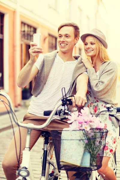 Couple avec vélos et smartphone dans la ville — Photo