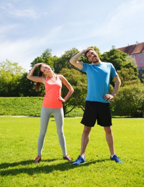 smiling couple stretching outdoors clipart