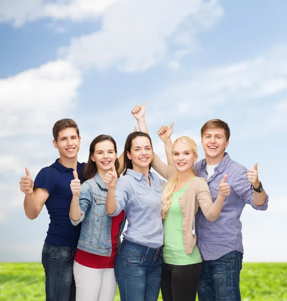 Grupo de estudiantes sonrientes mostrando pulgares hacia arriba — Foto de Stock