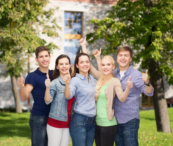 Grupo de estudantes sorrindo mostrando polegares para cima — Fotografia de Stock