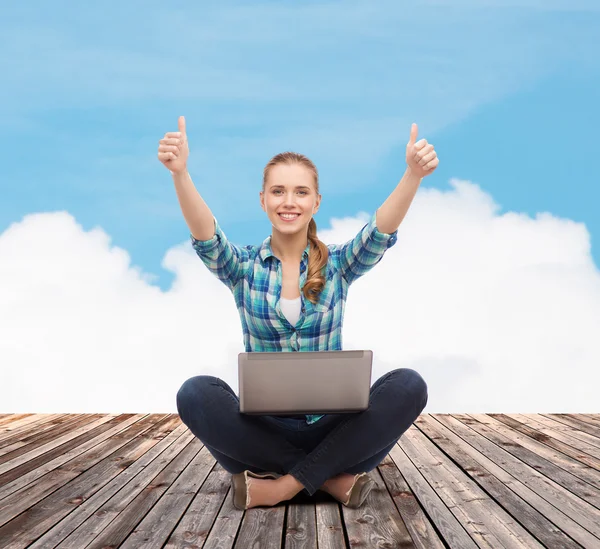 Mujer sonriente con portátil y mostrando los pulgares hacia arriba — Foto de Stock