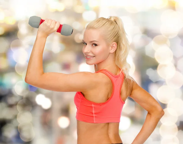 Jonge, sportieve vrouw met lichte dumbbell — Stockfoto