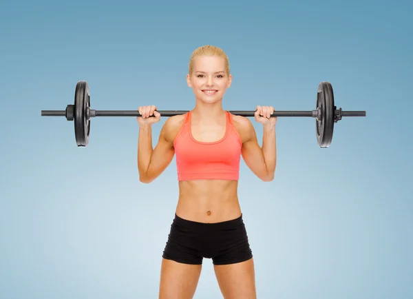 Glimlachende sportieve vrouw oefenen met lange halter — Stockfoto