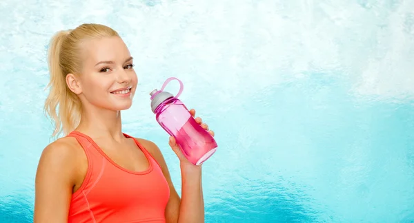 Mujer deportiva sonriente con botella de agua — Foto de Stock