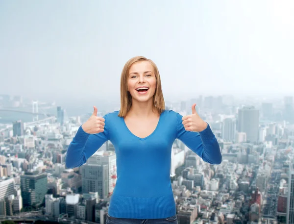 Sonriente chica en ropa casual mostrando los pulgares hacia arriba — Foto de Stock