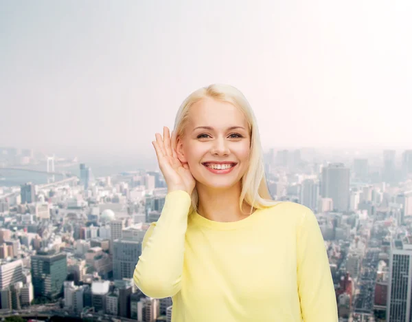 Sorrindo jovem mulher ouvindo fofocas — Fotografia de Stock