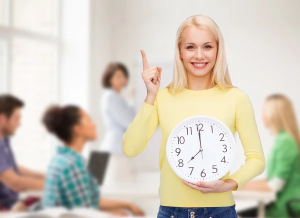 Student with wall clock and finger up — Stock Photo, Image
