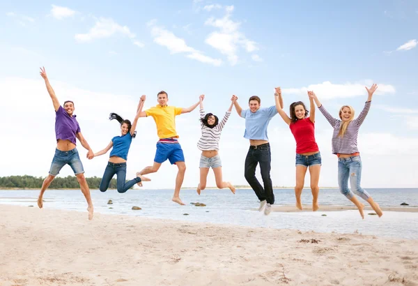 Grupo de amigos pulando na praia — Fotografia de Stock