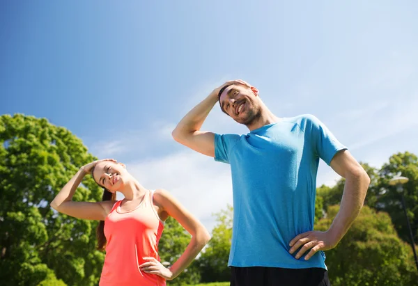 Sorridente coppia che si estende all'aperto — Foto Stock