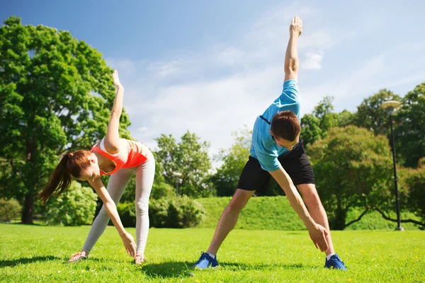 Smiling couple stretching outdoors — Stockfoto