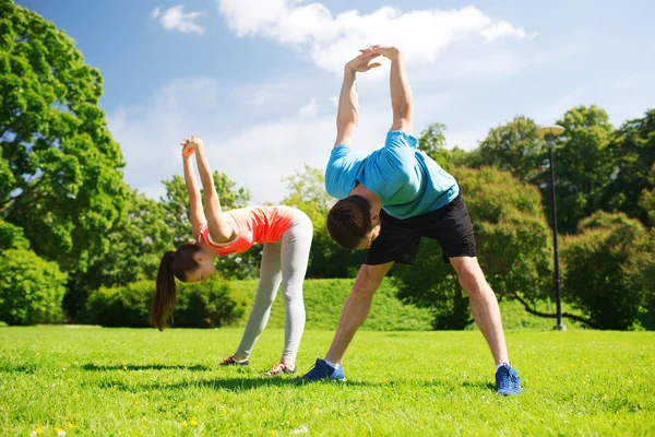 Lächelndes Paar streckt sich im Freien — Stockfoto