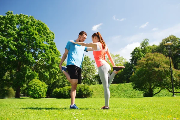 Smiling couple stretching outdoors — Stockfoto