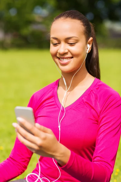 Smiling african american woman with smartphone — Stock Photo, Image