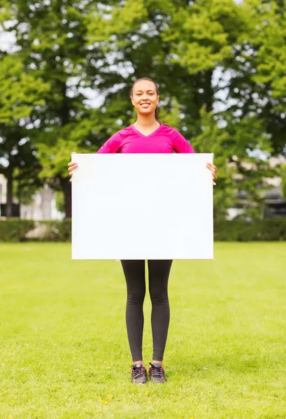 Lächelndes Teenager-Mädchen mit leerem weißen Brett — Stockfoto