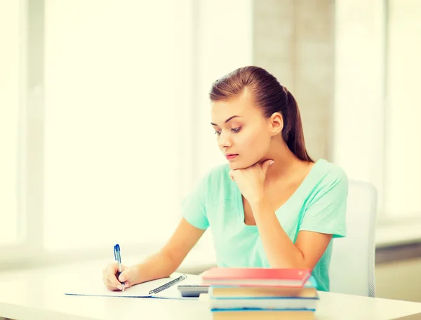 Estudiante cansado escribiendo en cuaderno — Foto de Stock