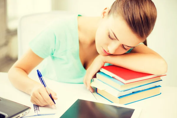 Estudante cansado dormindo em estoque de livros — Fotografia de Stock