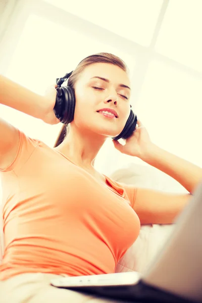 Mujer con auriculares y portátil en casa — Foto de Stock