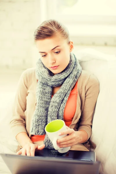 Хворі жінки в шарфі використовують ноутбук вдома — стокове фото