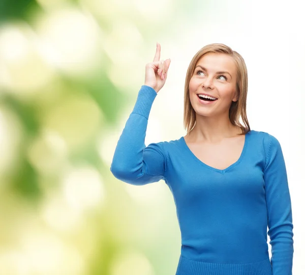 Smiling woman pointing her finger up — Stock Photo, Image