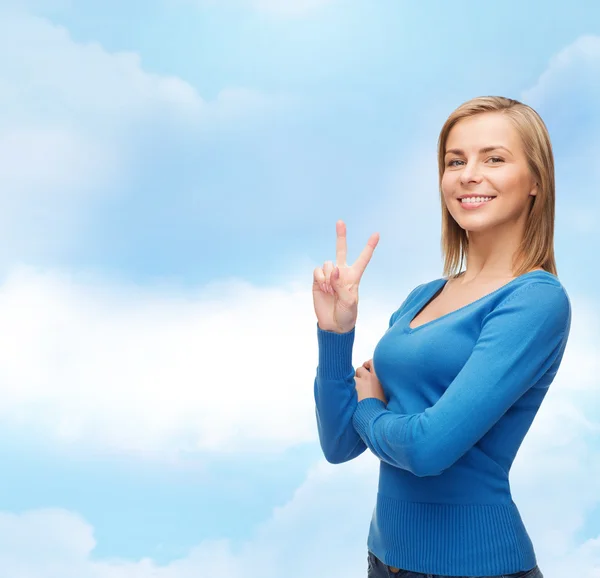 Smiling teenage girl showing v-sign with hand — Stock Photo, Image