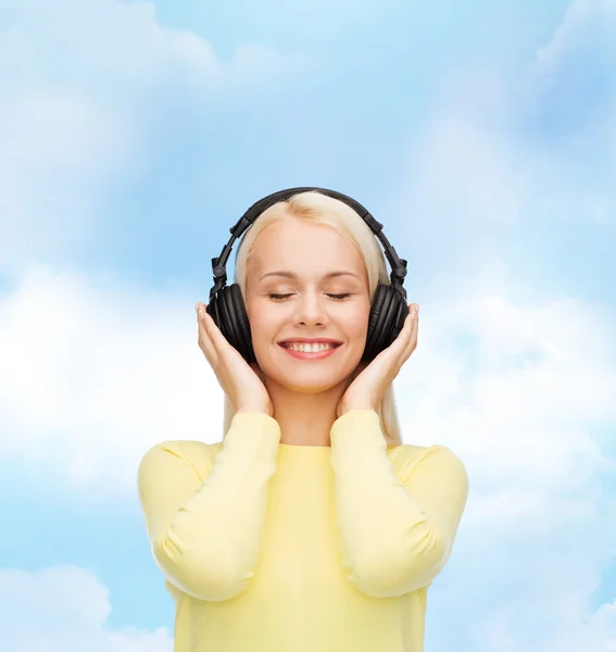 Lächelnde junge Frau mit Kopfhörern — Stockfoto