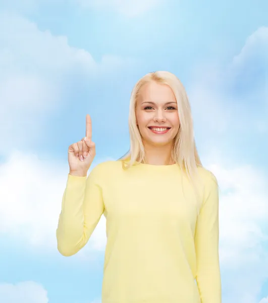 Mujer sonriente señalando con el dedo hacia arriba — Foto de Stock