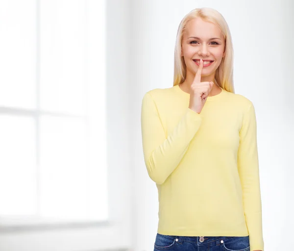 Young woman with finger on her lip — Stock Photo, Image