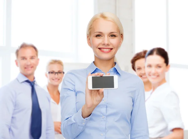 Mujer de negocios sonriente con pantalla en blanco para teléfonos inteligentes —  Fotos de Stock