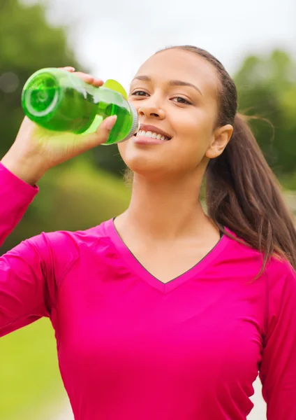 Sonriente mujer bebiendo de botella —  Fotos de Stock