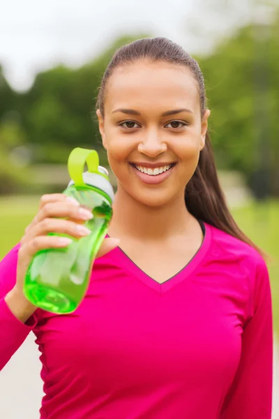 Smiling woman drinking from bottle — Stock Photo, Image