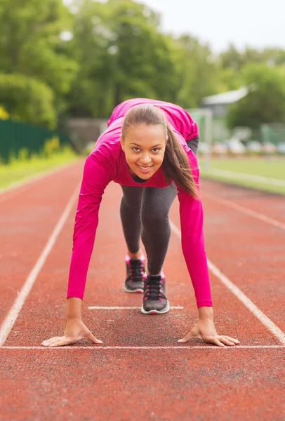 Sonriente joven corriendo en pista al aire libre —  Fotos de Stock