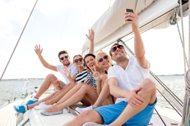 smiling friends sitting on yacht deck clipart