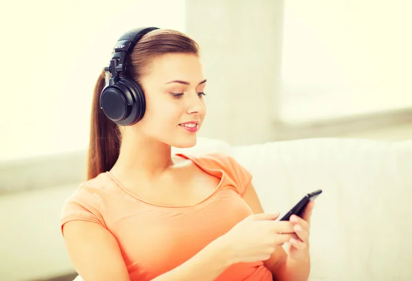 Woman with headphones and smartphone at home — Stock Photo, Image