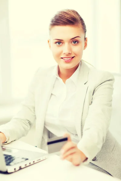 Zakenvrouw met laptop per creditcard — Stockfoto