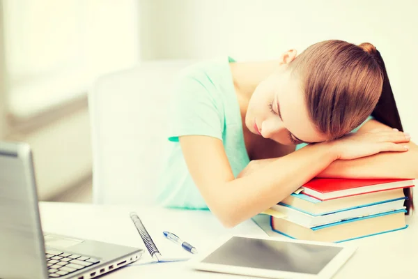 Estudante cansado dormindo em estoque de livros — Fotografia de Stock