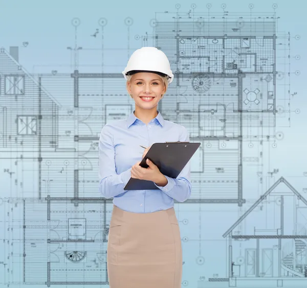 Smiling businesswoman in helmet with clipboard — Stock Photo, Image