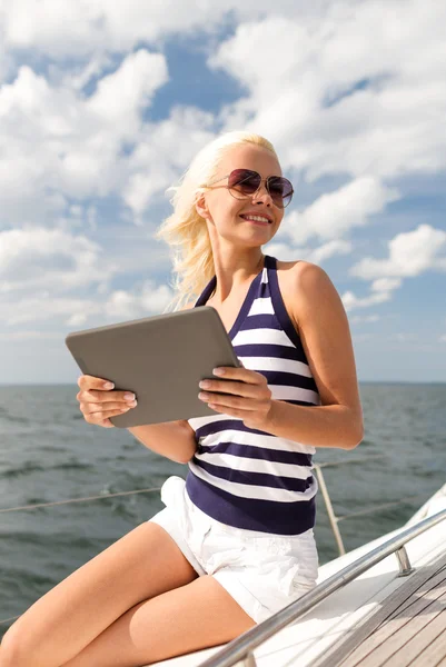 Mulher sorridente sentado no iate com tablet pc — Fotografia de Stock