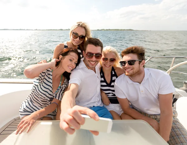 Amici sorridenti seduti sul ponte dello yacht — Foto Stock